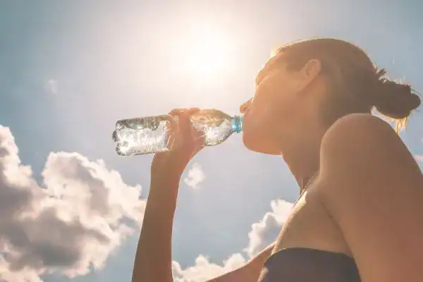 Hydration: The Secret Ingredient for a Toned Stomach and Enhanced Fitness 3 Image of woman drinking water to hydrate Matlock after run.