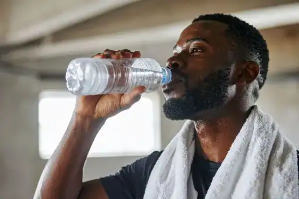 Hydration: The Secret Ingredient for a Toned Stomach and Enhanced Fitness 1 Image of man drinking water to improve hydration Matlock after work out.